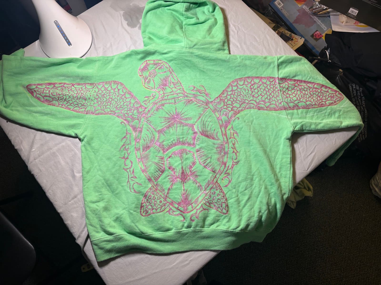 Hand-painted pink sea turtle design, back view, on a custom sweatshirt by Madeleine MacNutt